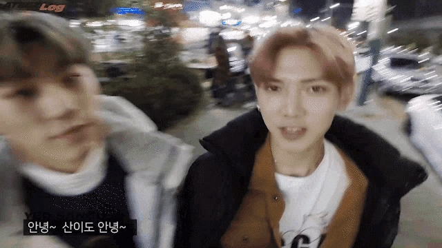 a blurry photo of two young men with the word log in the upper right corner