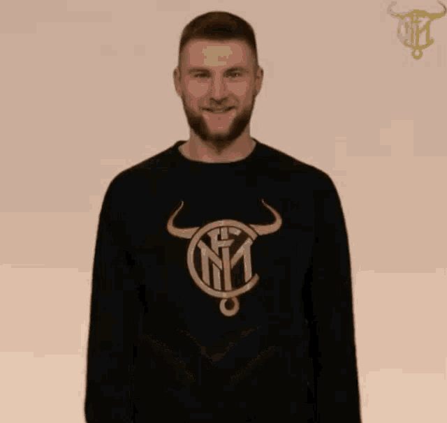 a man wearing a black sweater with a bull and the letter n on it
