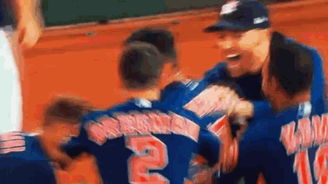 a group of baseball players are hugging each other and one of the players has the number 2 on his back
