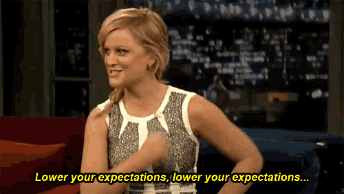 a woman is sitting on a couch and says lower your expectations