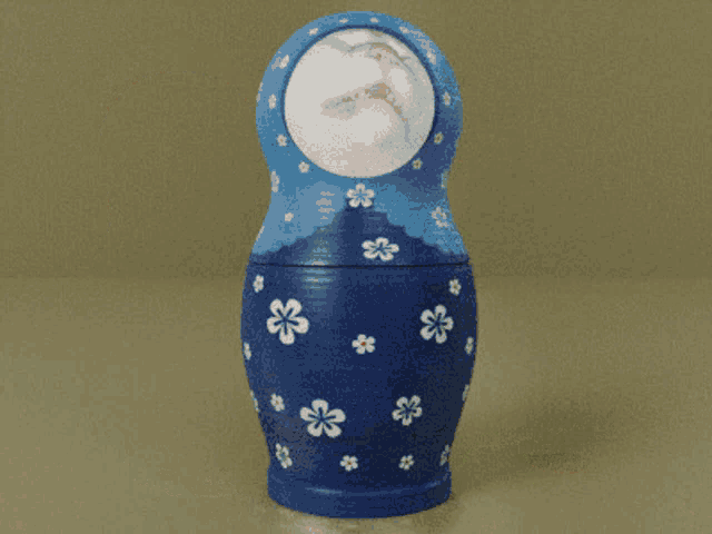 a blue green and orange russian nesting doll with flowers on them