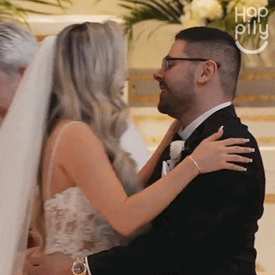 a bride and groom are hugging each other in front of a sign that says " hap pillu "
