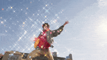 a man in a red jacket is standing in front of a building with his arms outstretched in the air