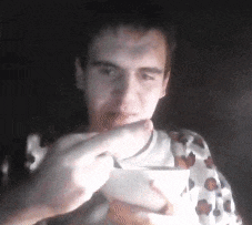 a man is eating soup from a bowl with a spoon in his hand .