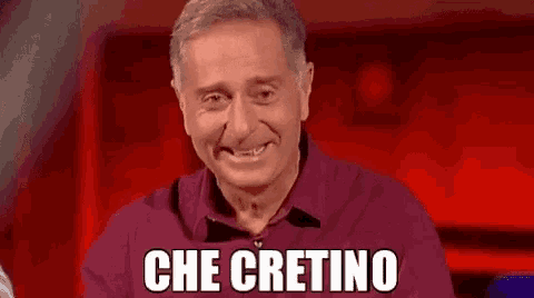 a man in a purple shirt is smiling with the words che cretino written below him .