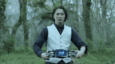 a man in a white vest and black shirt is holding a belt in his hands .