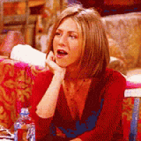 a woman in a red shirt is sitting at a table with a bottle of water .
