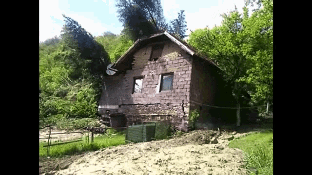 a small brick house in the middle of a field