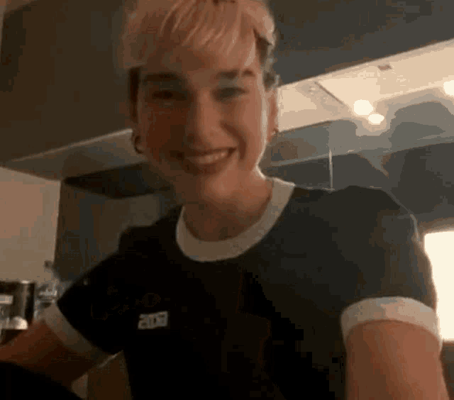 a woman with short hair is smiling and wearing a black t-shirt with the year 2009 on it .