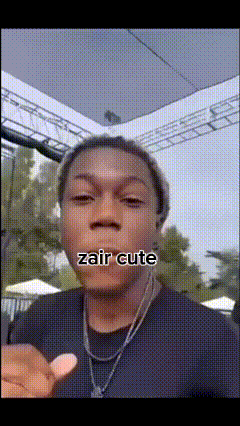 a man wearing a black shirt and a necklace says " zair cute "