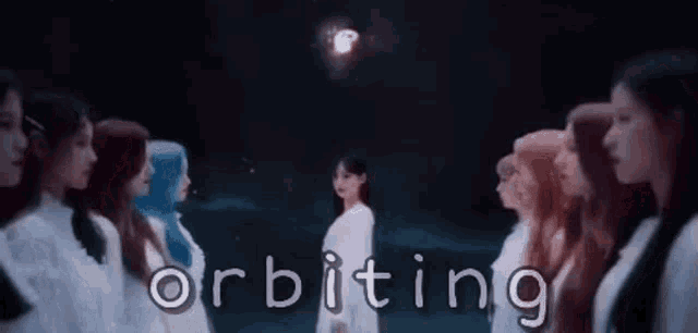 a group of women are standing next to each other in a dark room with the words orbiting written on the bottom .