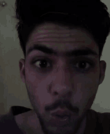 a man with a beard is looking at the camera with his mouth open