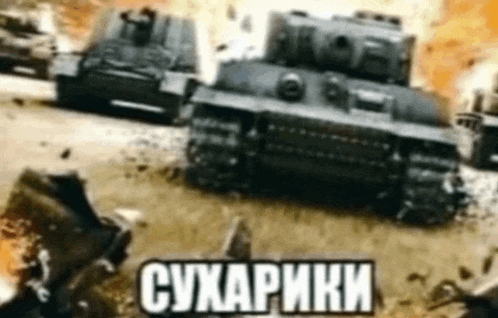 a group of tanks are driving down a road in a battle .