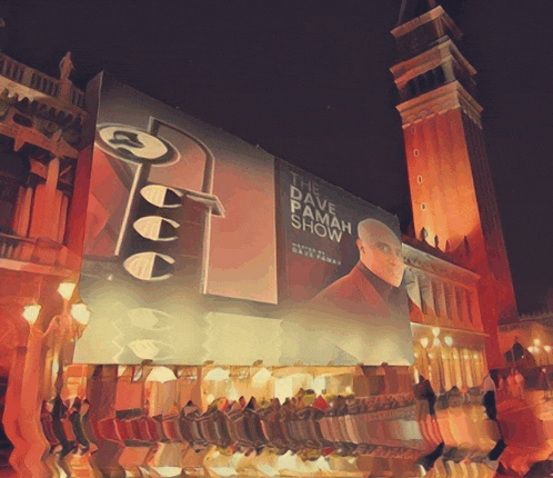 a large billboard for the dave pamah show is lit up at night