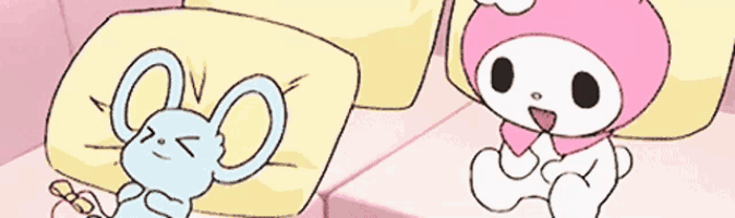 a blue rabbit is laying on a bed next to a pink bunny