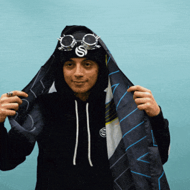 a man wearing a black hoodie and goggles with the letter s on them