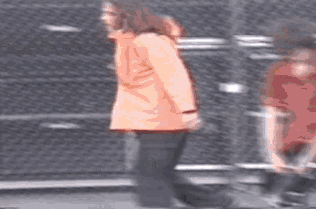 a blurry picture of a woman in an orange coat walking