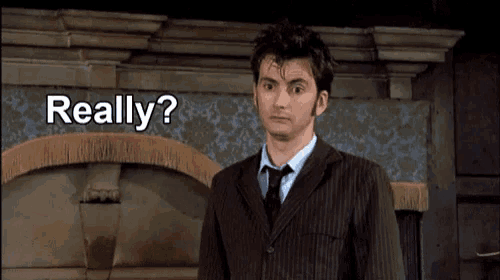 a man in a suit and tie is standing in front of a wall that says really