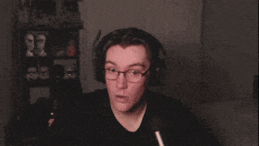 a man wearing glasses and headphones making a face