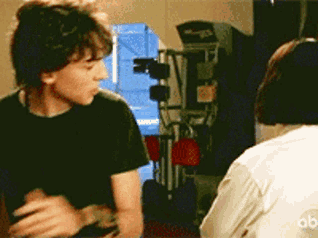 a man in a black shirt talks to a woman in a white shirt