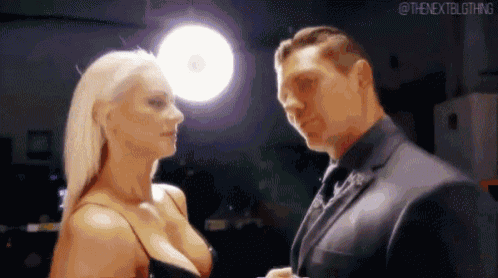 a man and a woman are looking at each other in a room .