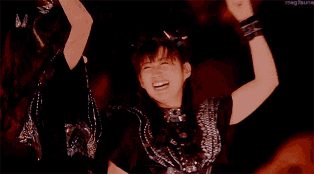 a girl in a black dress is dancing on a stage .