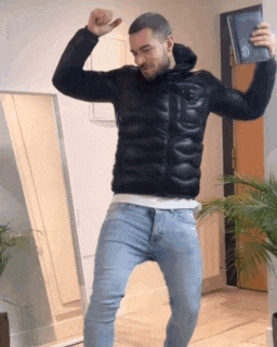 a man is dancing in a living room while holding a book .