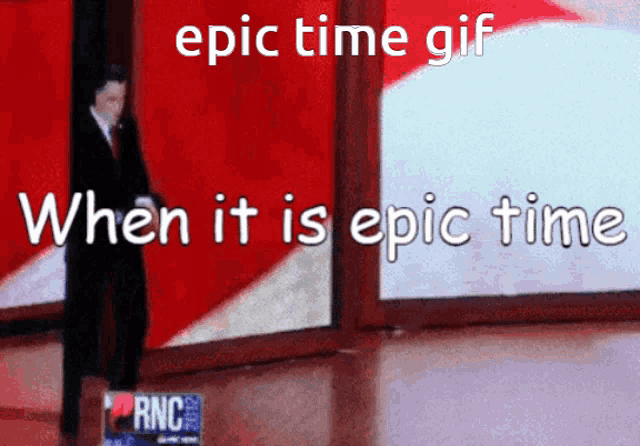 a man in a suit and tie is standing in front of a large screen that says epic time gif