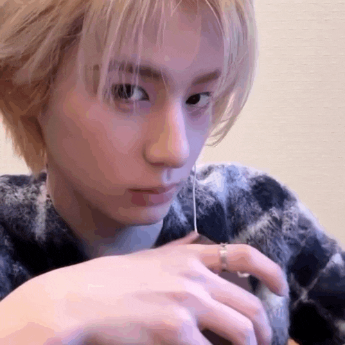 a close up of a person 's face with a ring on their finger