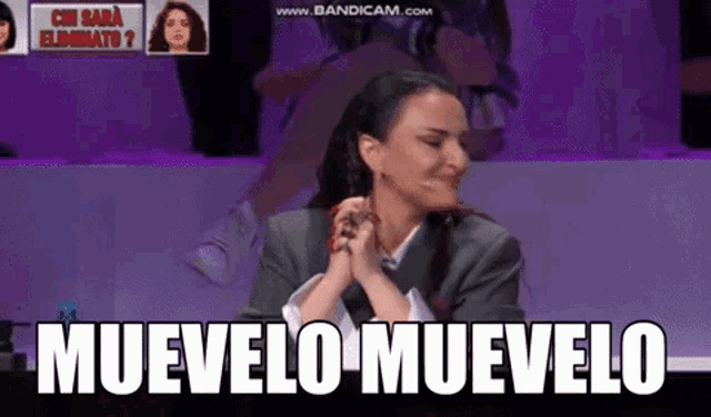 a woman is sitting at a table with the words muvelo muvelo written on the screen