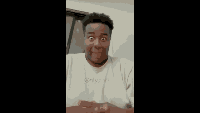 a man is making a funny face while wearing a white shirt with the word onlyfans on it .