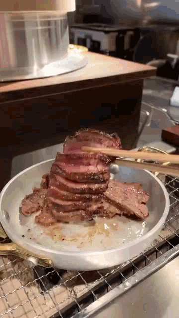 a piece of beef is being eaten with chopsticks