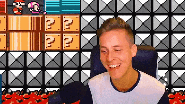 a man is sitting in front of a video game screen with a question mark on it .