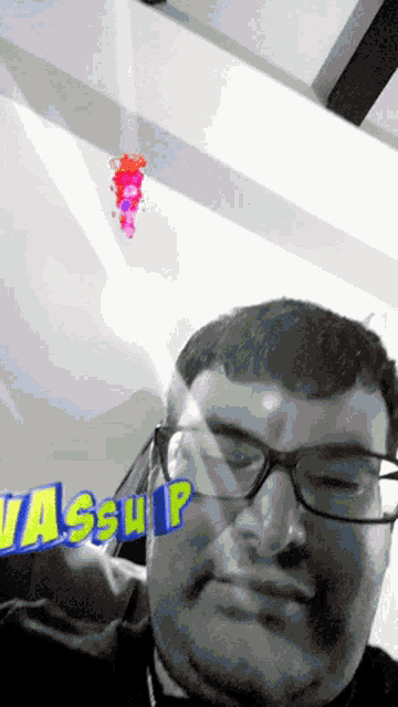 a man wearing glasses has the word wassup on his forehead
