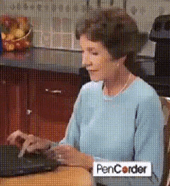 a woman is sitting at a table with a pencorder sticker
