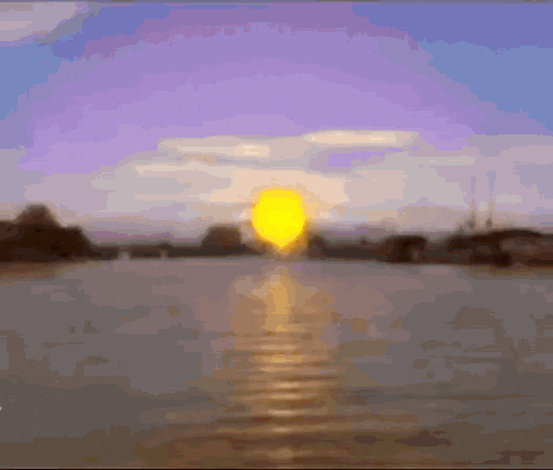 a sunset over a body of water with the sun shining brightly
