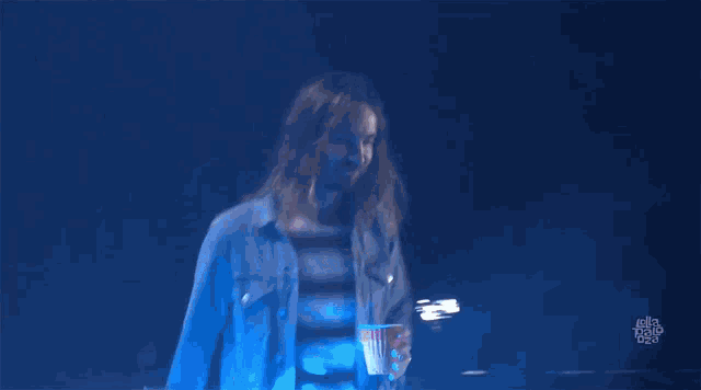 a person in a blue shirt is raising their hand in the air