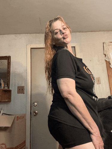 a woman in a black shirt stands in front of a door that says medium