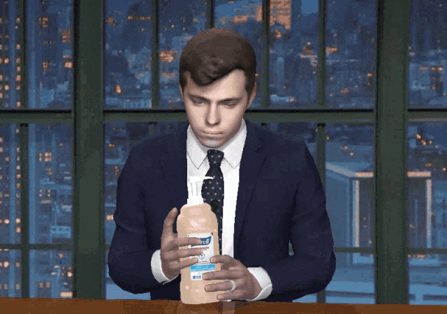 a man in a suit and tie is holding a bottle of purell hand sanitizer