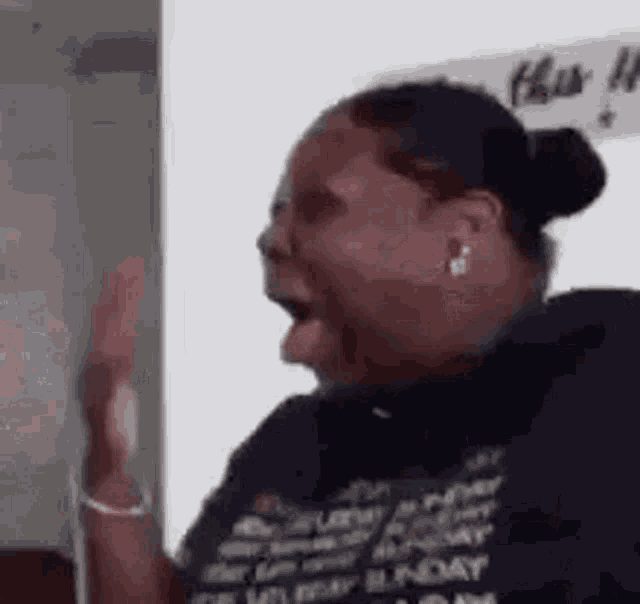 a woman is making a funny face with her mouth open and her hands in the air .