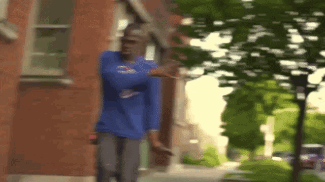 a blurry picture of a man in a blue shirt walking down a sidewalk