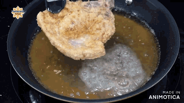 a pan with a piece of fried meat in it and the words made in animotica on the bottom
