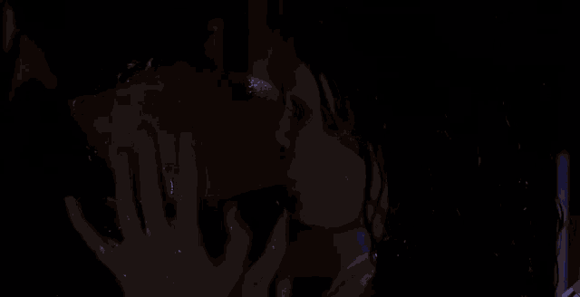 a man and a woman are kissing in a dark room .