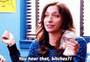 a woman in a blue sweater is holding a bag of food and saying you hear that , bitches ?
