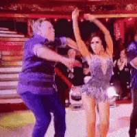 a man and a woman are dancing on a stage in front of a crowd .
