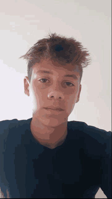 a young man taking a selfie with his hair blowing in the wind
