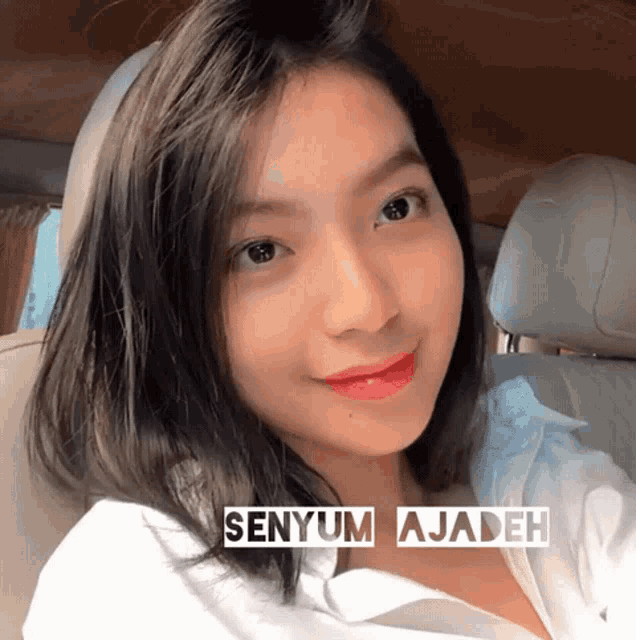 a woman in a car with the words senyum ajadeh on the bottom