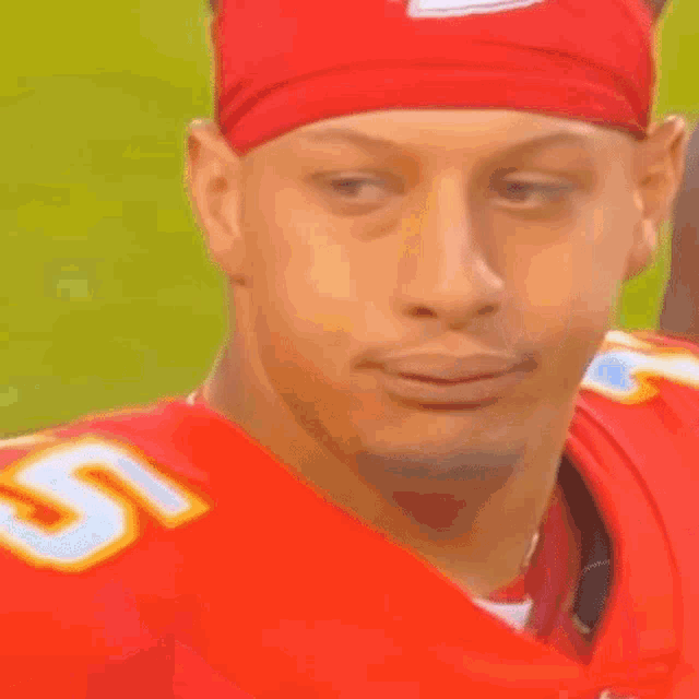 a man wearing a red headband with a kc logo on it