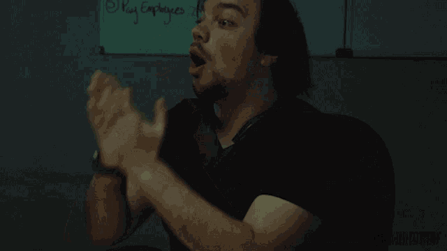 a man covering his face with his hands in front of a white board that says poly explorer
