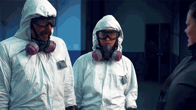 a man and a woman wearing white suits and masks